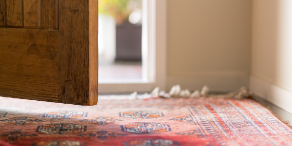 A door opening above a red rug
